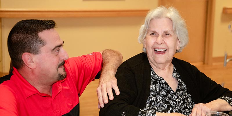 Caregiver smiling with elderly resident